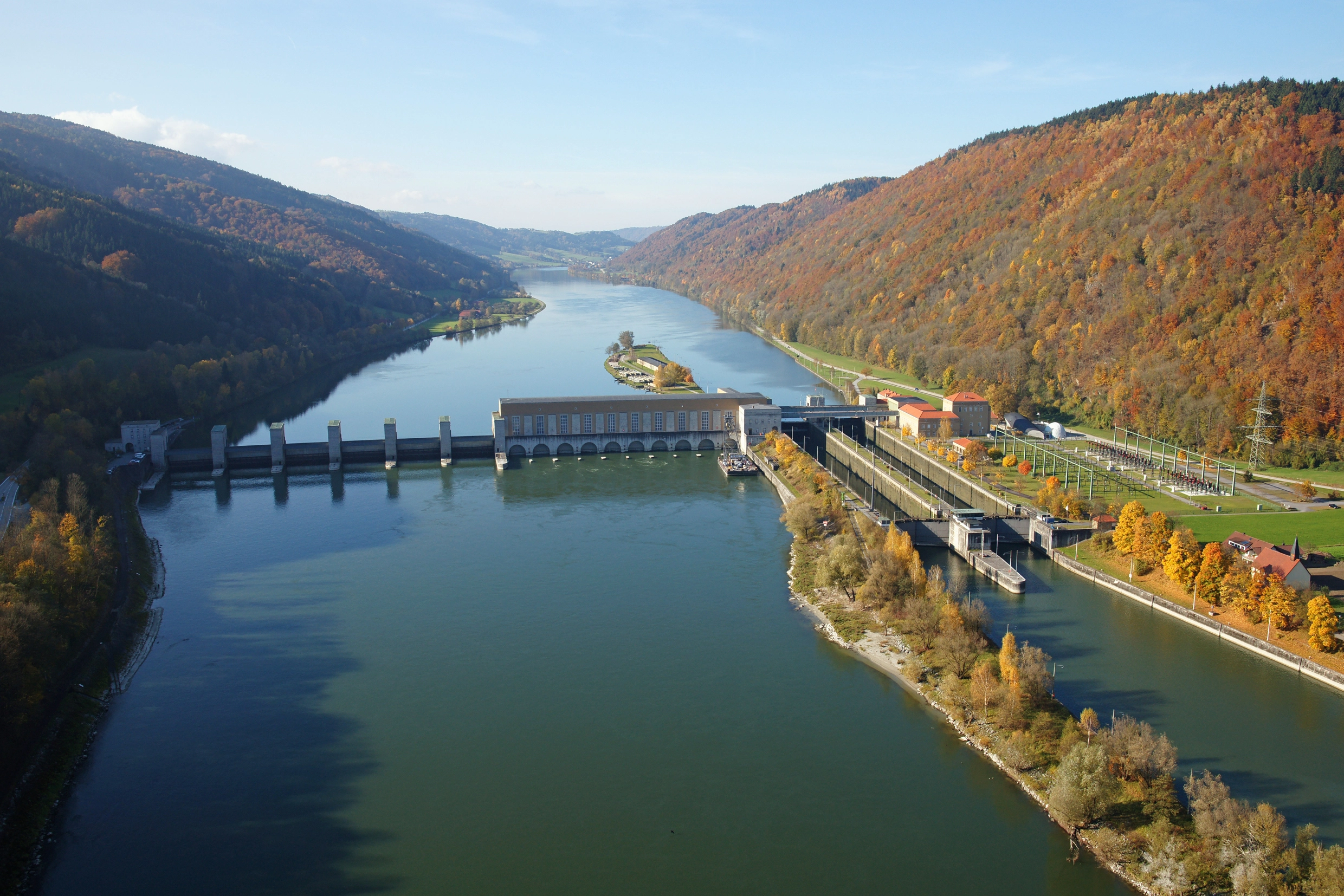 Ein Blick von oben das Kraftwerk Jochenstein im herbstlichen Setting.